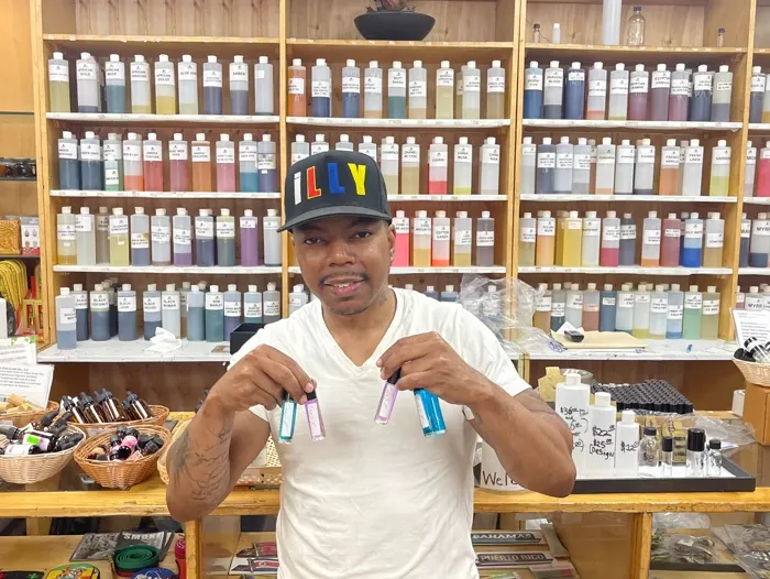 Customer with fragrance oils in front of the Nicholas Brooklyn perfume oil wall